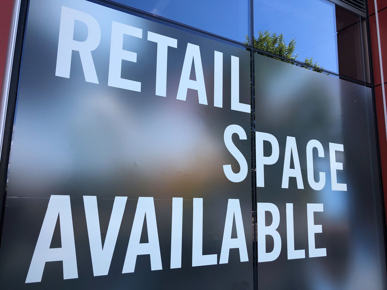 A sign in a glass storefront window reads "Retail Space Available."