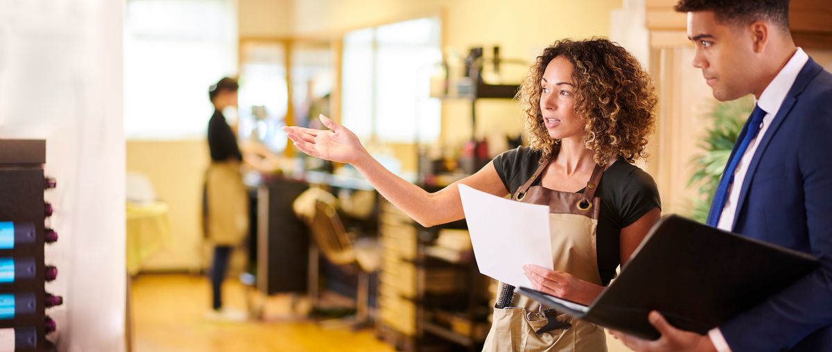 A salon owner shows a property insurance agent around the business.
