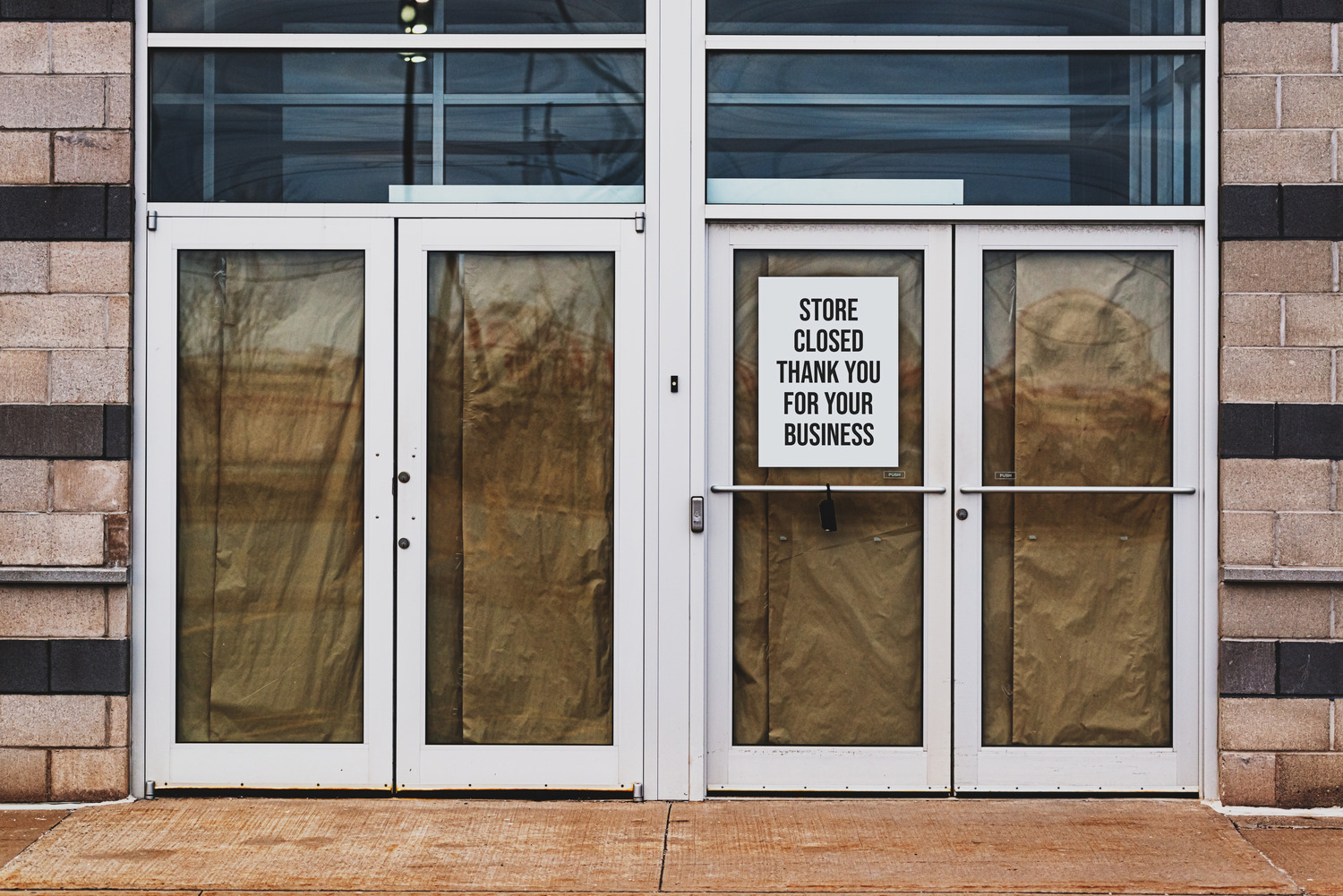 A commercial borrower foreclosed on their retail space, putting a sign that says, "Store Closed. Thank you for your business," in the glass door.